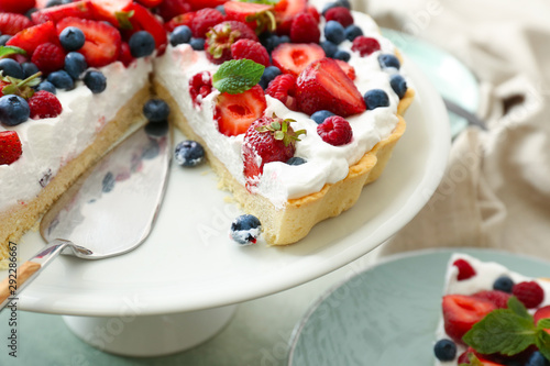 Stand with tasty berry pie on table, closeup