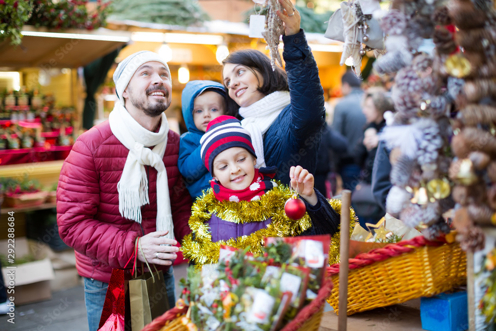 Smiling family of four buying holidays decorations