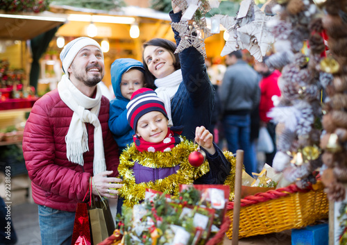 Cheerful family of four buying holidays decorations