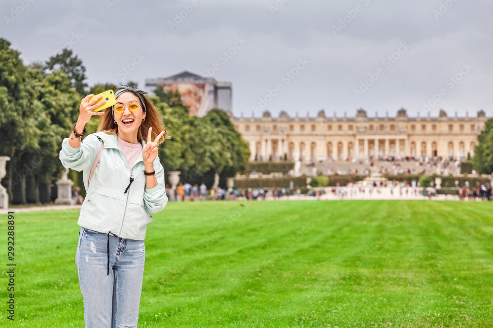 Happy girl travels to Versailles and admires the wonderful view of the Palace and garden Happy girl travels to Versailles and admires the wonderful view of the Palace and garden