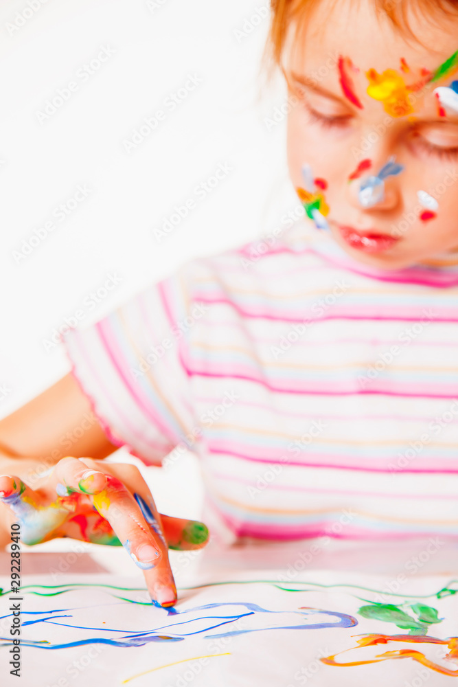 Art, creativity, childhood concept. Close up cute young girl painting with colorful hands. Selective focus on fingers.