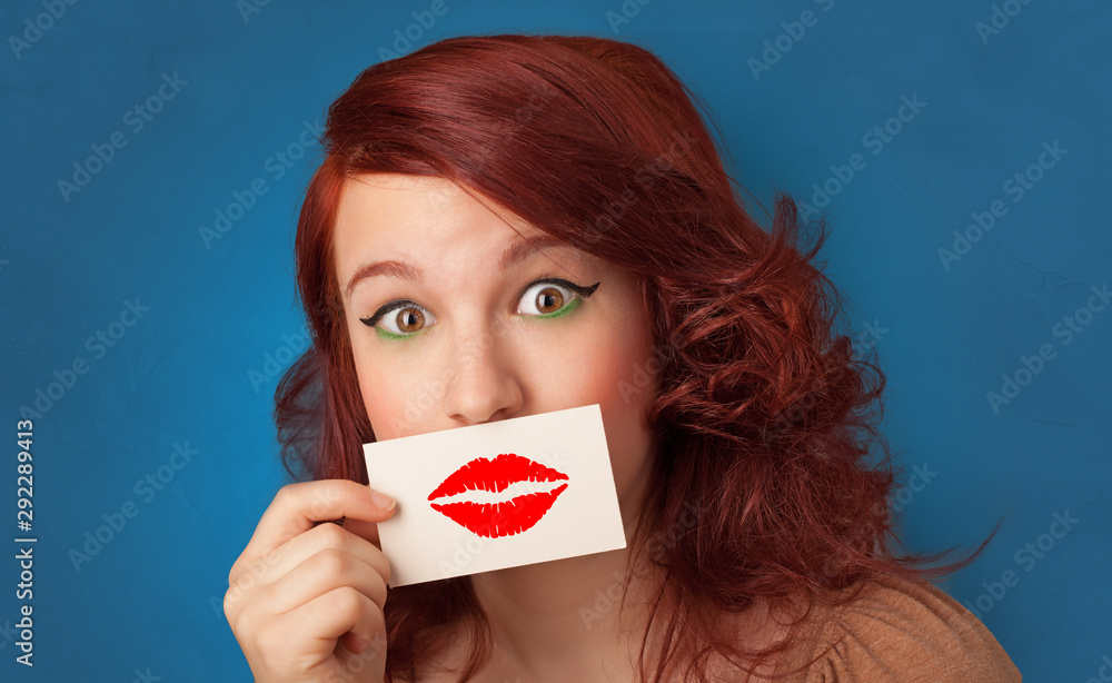 Person smiling with a card on the front of his mouth with a red lips on it Person smiling with a card on the front of his mouth with a red lips on it