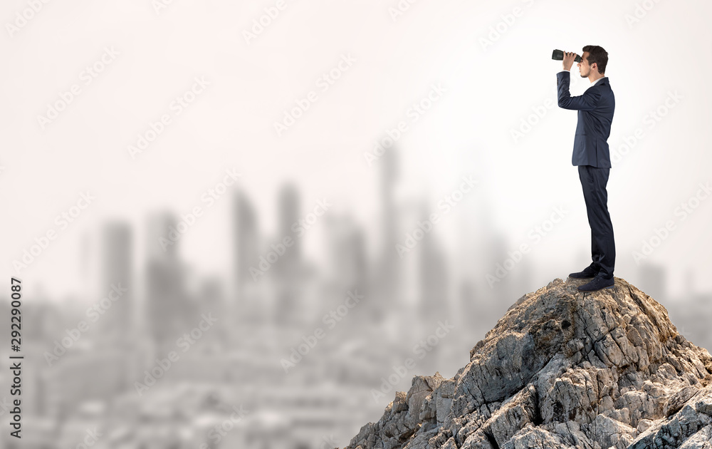 Young business person looking to the city from distance Young business person looking to the city from distance