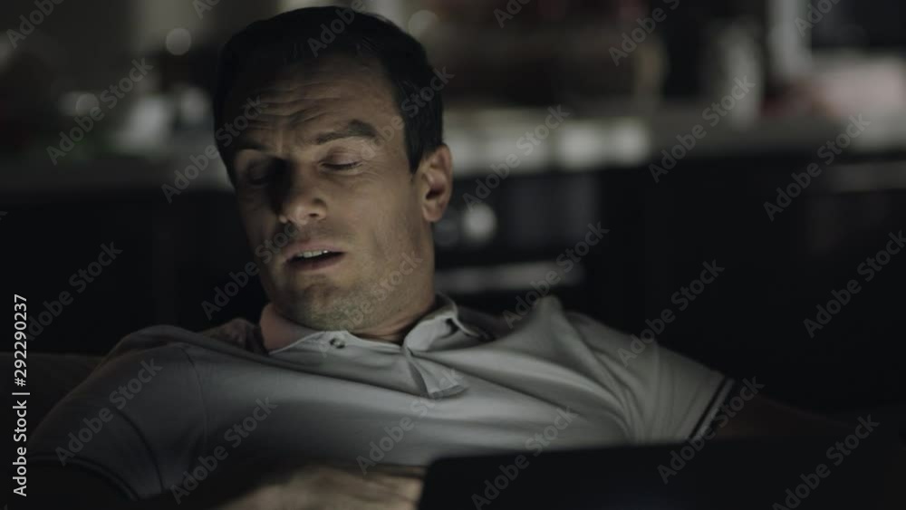 Exhausted businessman working late at remote workplace. Exhausted businessman working late at remote workplace.