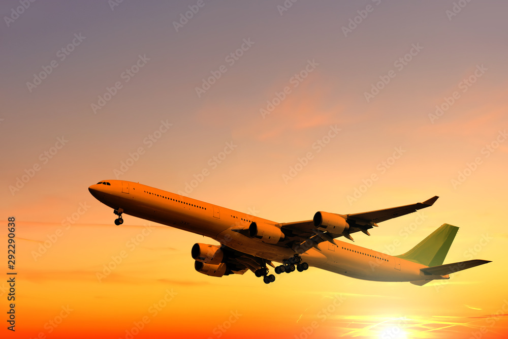 modern airplane flying against beautiful sunset sky background aerial wide  view of passenger aircraft landing in setting sun landscape business jet plane  takeoff on sunrise light air travel wallpaper Stock Photo |