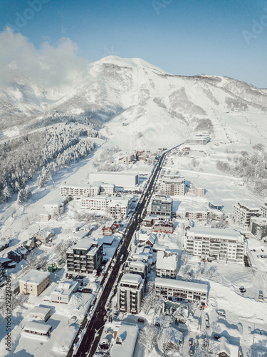 Winter in Niseko, Japan. A blue bird kind of day at Grand Hirafu, Niseko Ski Resort. Photos were taken with a drone overlooking the Grand Hirafu area with views of Mt. Niseko-Annupuri. and Mt. Yotei.
