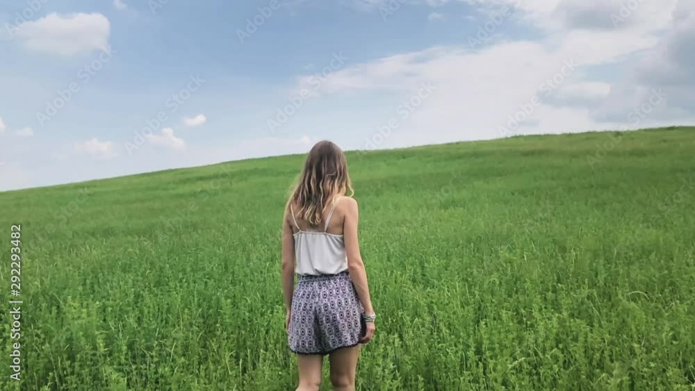 Cute young woman jumping in a green field. Cute young woman jumping in a green field.