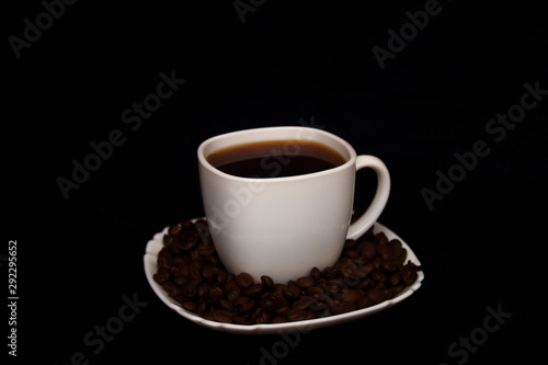 cup of coffee with coffee beans on black background