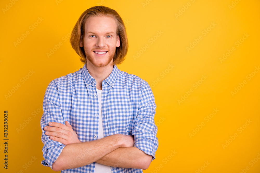Photo of handsome attractive guy wearing blue shirt with arms crossed beaming toothy smile confident isolated over vivid color yellow background Photo of handsome attractive guy wearing blue shirt with arms crossed beaming toothy smile confident isolated over vivid color yellow background