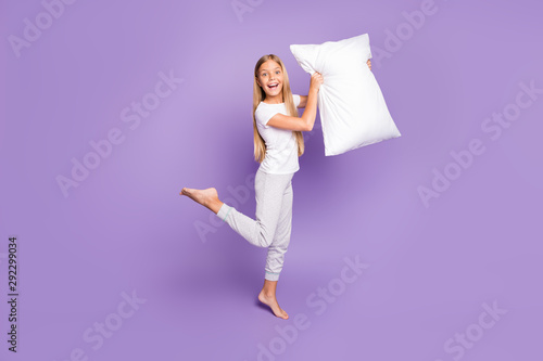 Full body photo of funny funky crazy emotions blonde hair girl barefoot hold pillow want play game sleep-over party with best friends sisters wear white t-shirt pants isolated purple color background