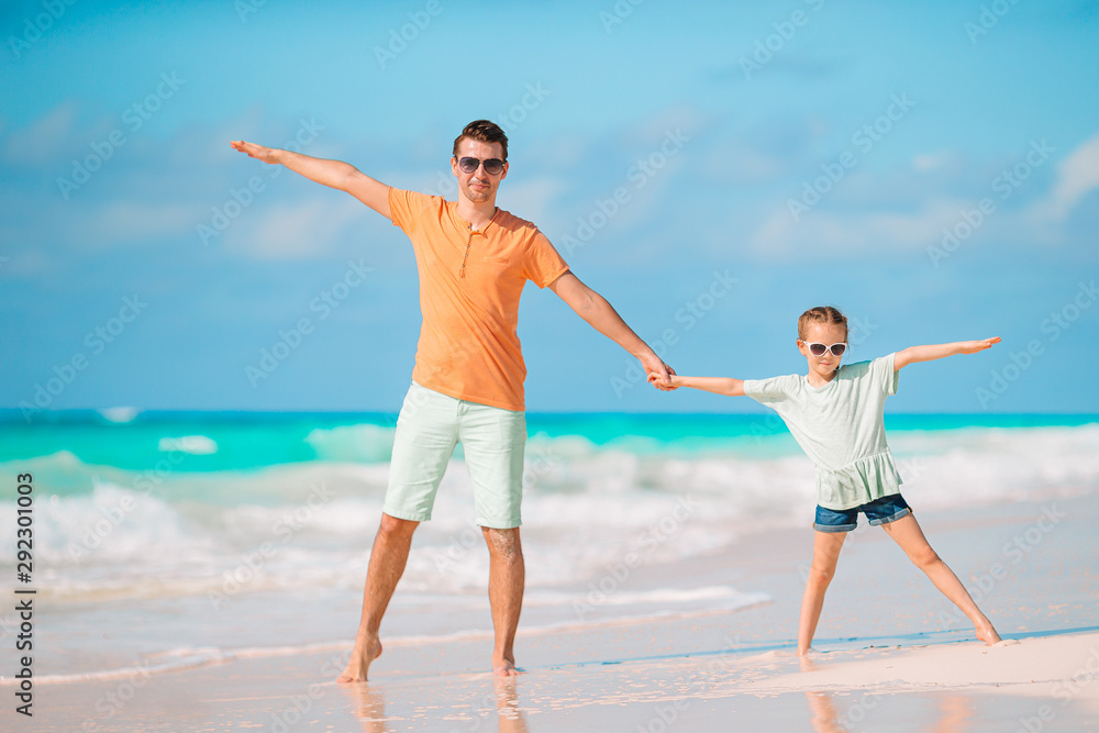 Little girl and happy dad having fun during beach vacation Little girl and happy dad having fun during beach vacation