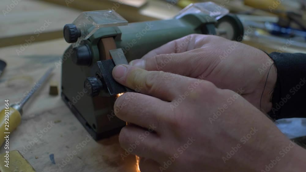 Close-up, worker sharpening a chisel on a grindstone, sparks beautifully fly out from under the stone. 4k. 4k video. slow motion. 24 fps Close-up, worker sharpening a chisel on a grindstone, sparks beautifully fly out from under the stone. 4k. 4k video. slow motion. 24 fps
