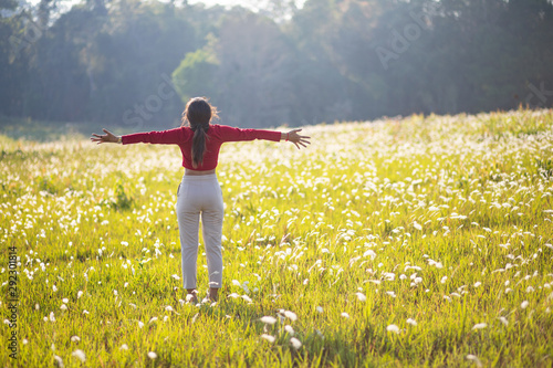 Hipster Asian woman in red and sunglasses on white flower and grass field