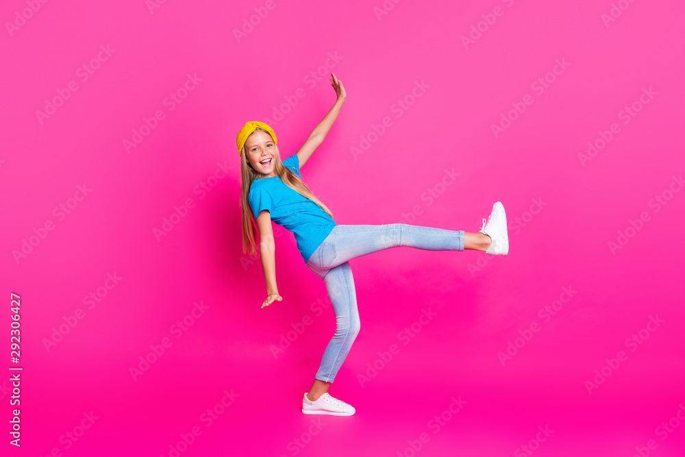Full size photo of content candid funky funny child raise her leg have fun enjoy free time weekends wear bright outfit sneakers isolated over pink color background Full size photo of content candid funky funny child raise her leg have fun enjoy free time weekends wear bright outfit sneakers isolated over pink color background