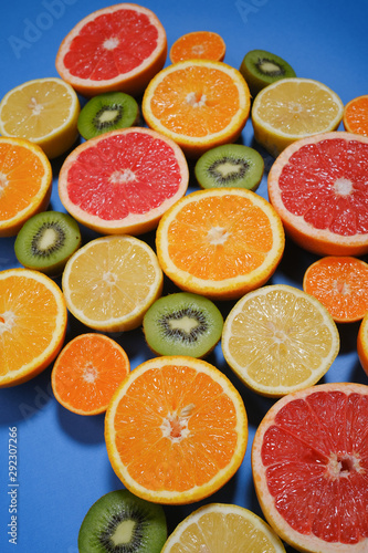 Fresh summer fruits on blue background. Healthy food concept. Flat lay. Tropical summer mix grapefruit, orange, mandarin, kiwi, lemon