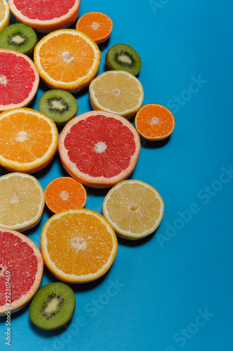 Fresh summer fruits on blue background. Healthy food concept. Flat lay. Tropical summer mix grapefruit, orange, mandarin, kiwi, lemon © Oleg Samoylov