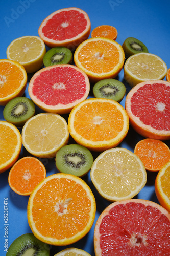 Fresh summer fruits on blue background. Healthy food concept. Flat lay. Tropical summer mix grapefruit  orange  mandarin  kiwi  lemon