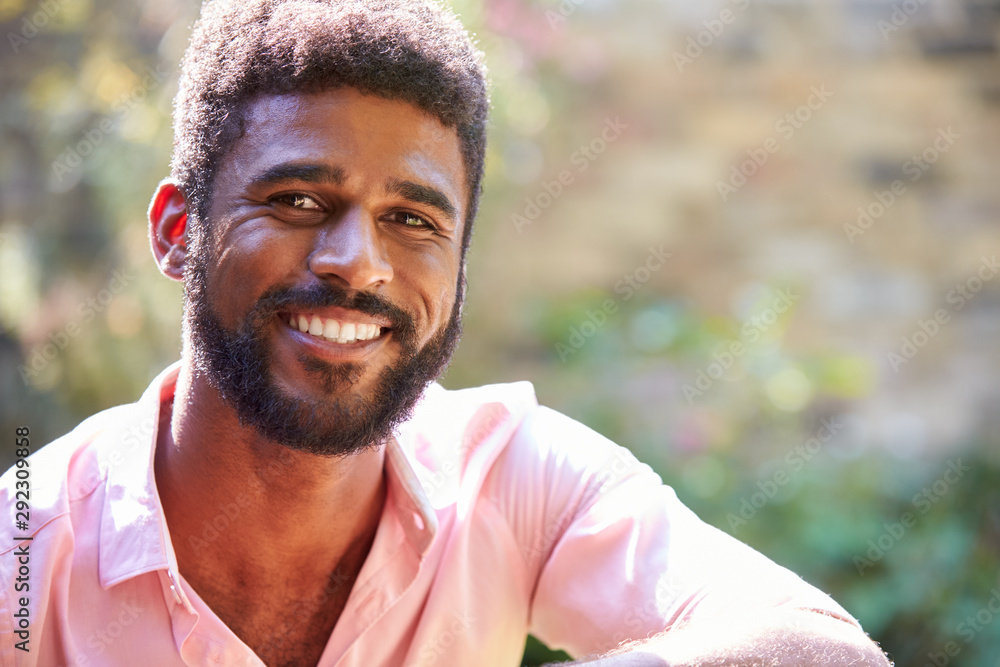 Portrait Of Smiling Man At Home In Garden Against Flaring Sun Portrait Of Smiling Man At Home In Garden Against Flaring Sun