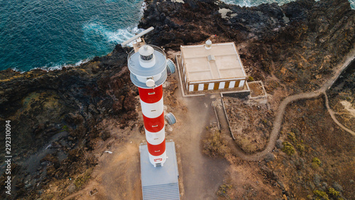 Punta Abona lighthouse. Landscape overlooking the ocean. Sunset. The water is shiny. Aerial. Tenerife Island, Spain photo