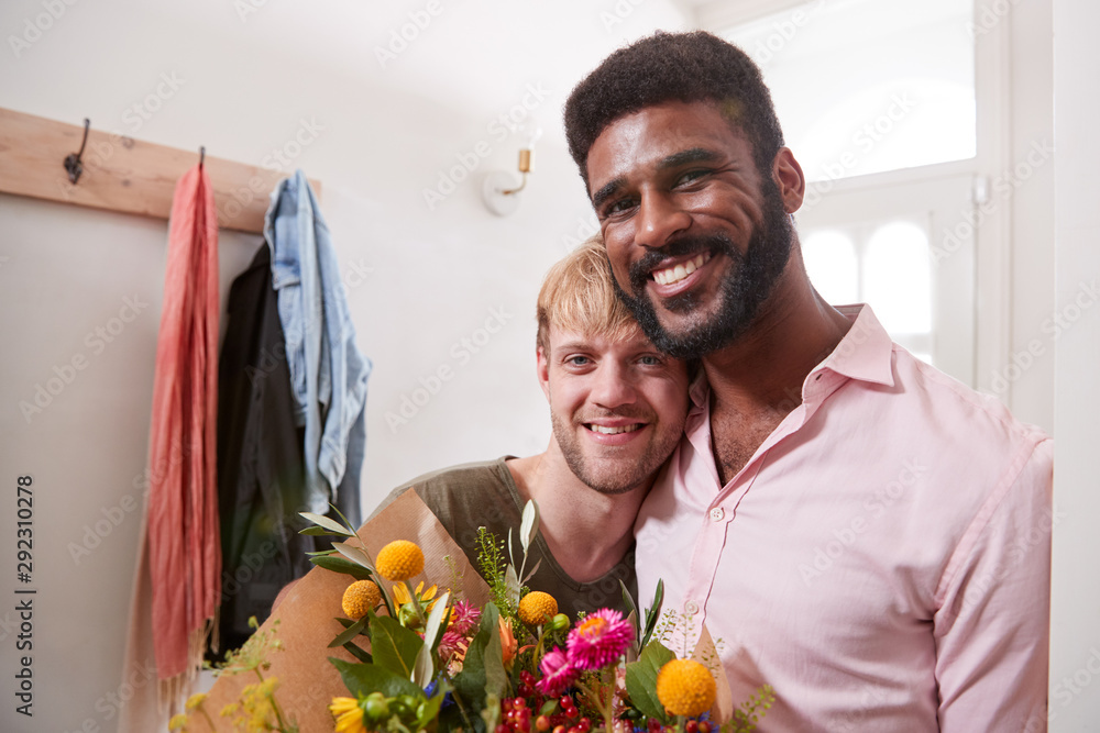 Φωτογραφία Portrait Of Man Giving Gay Partner Bunch Of Flowers In Hallway At Home