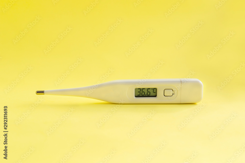 Digital medical thermometer with temperature of 36.6 on light yellow background. Digital medical thermometer with temperature of 36.6 on light yellow background.