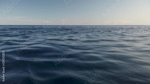 View of calm ocean water surface with small waves and empty horizon, slow motion photo