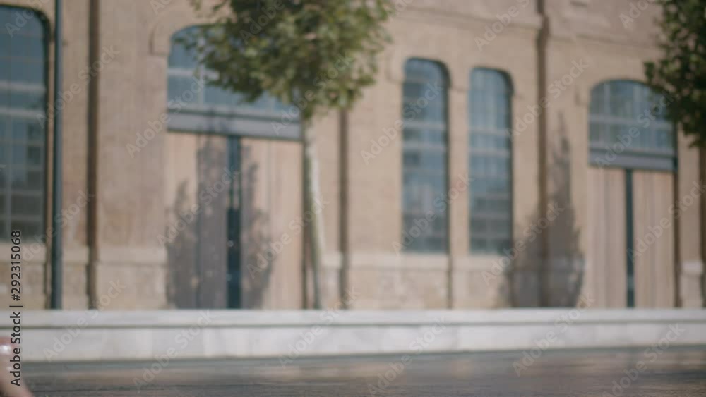 A boy in swimming shorts running through a fountain jet and getting wet