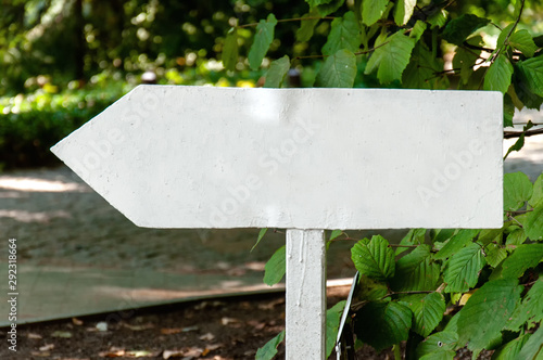 Wooden, white signpost in a park close-up.