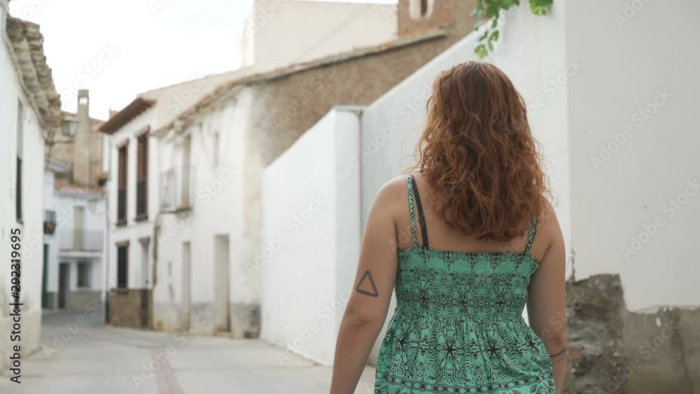 Back View Of Woman Walking At Rural Street In Andalusia Back View Of Woman Walking At Rural Street In Andalusia