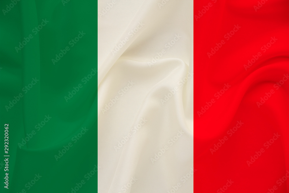 The national flag of the country of Italy on gentle silk with wind folds, travel concept, immigration, politics, copy space, close-up