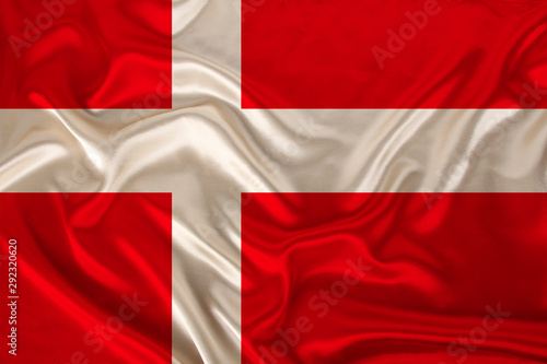 photo of the national flag of Denmark on a luxurious texture of satin, silk with waves, folds and highlights, close-up, copy space, concept of travel, economy and state policy, illustration