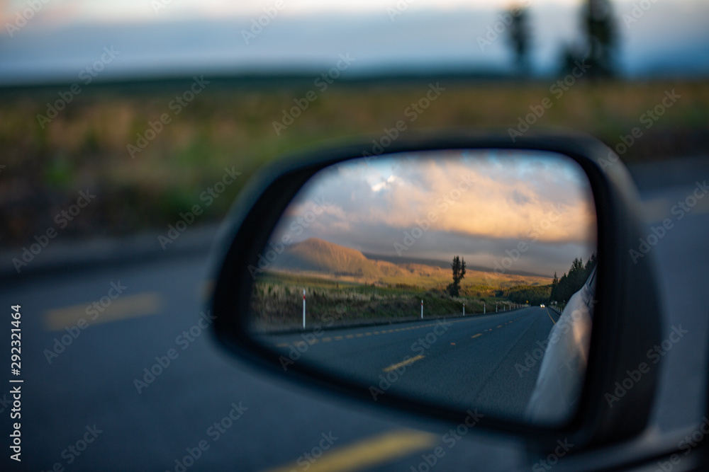 landscape seen through the rearview mirror of the car