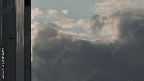 Slow moving clouds with modern building at a side