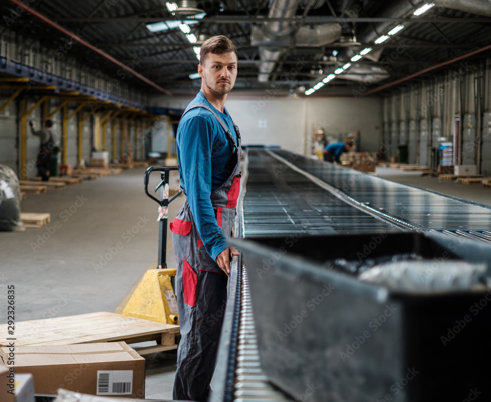 Warehouse worker working on a conveyor line Warehouse worker working on a conveyor line