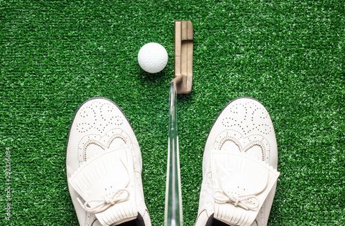 Studio shot, Flat lay of golf shoes putter and golf ball on the green fake grass photo