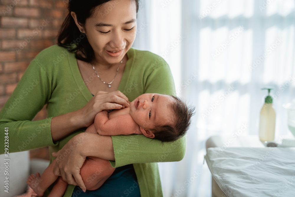 asian mother carry little baby daughter in the house asian mother carry little baby daughter in the house