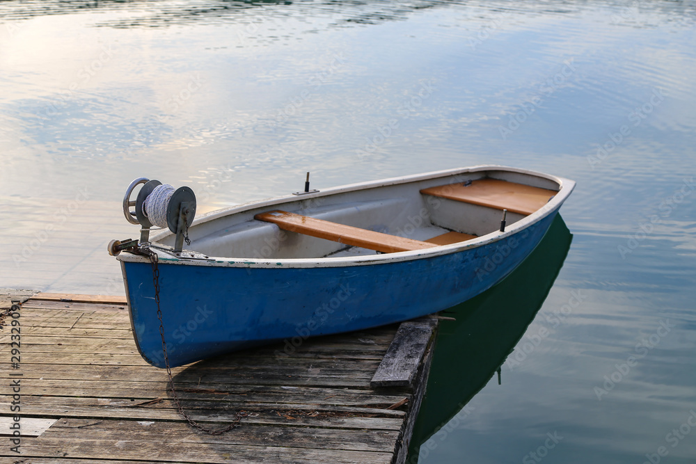 Blue fishing boat stands on a quiet lake