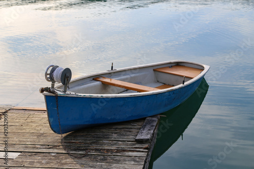 Blue fishing boat stands on a quiet lake © leomalsam