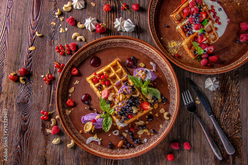 Varieties of Belgian waffles with blueberry cream and cheese cream, granola, nuts and fresh berries, rustic style, Tasty breakfast, Horizontal orientation, Top view