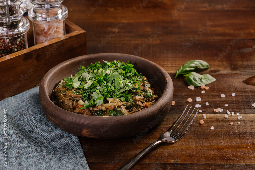 Dish with chopped meat with sauce and herbs on the wooden background Dish with chopped meat with sauce and herbs on the wooden background