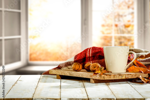 Fototapeta Naklejka Na Ścianę i Meble -  Autumn desk with mug and blurred fall window space 