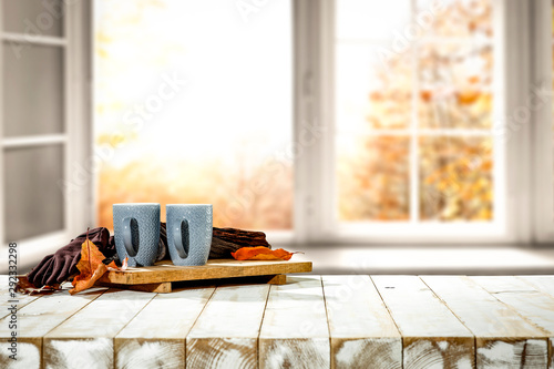Fototapeta Naklejka Na Ścianę i Meble -  Autumn desk with mug and blurred fall window space 
