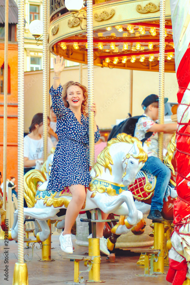 Young pretty woman closeup in different poses on the carousel background near Red square in Moscow