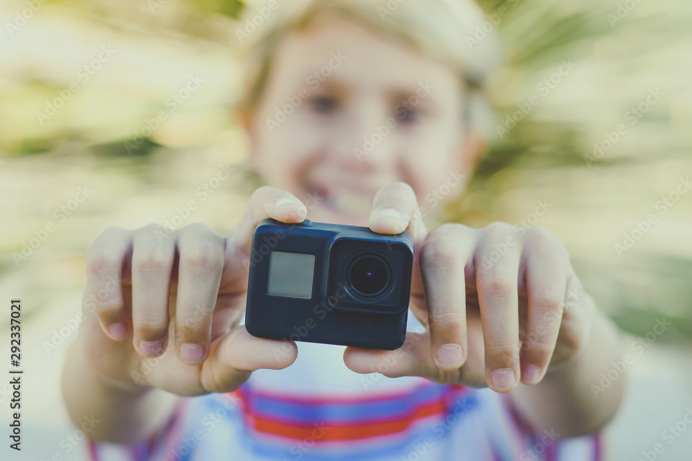 Closeup view of a smiling teen using action cam. Young blogger making video  for social story with GoPro camera. Student having fun with new multimedia  technology device. Trends tech, lifestyle concept Photos