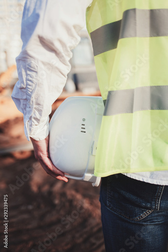 back view of male construction worker holding safety helmet outdoor