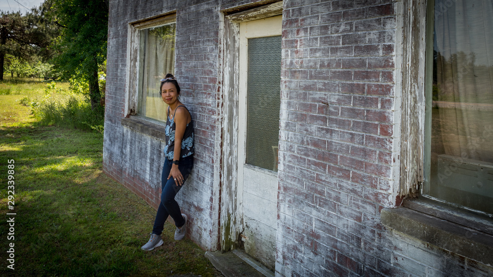 woman standing in front of dilapidated and abondoned restaurant in Virginia woman standing in front of dilapidated and abondoned restaurant in Virginia