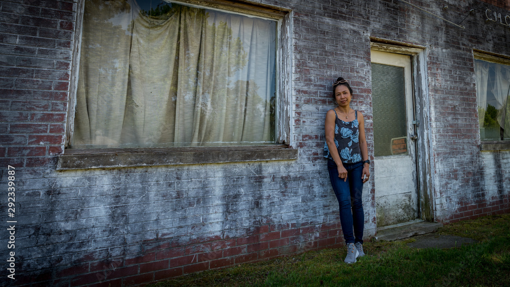 woman standing in front of dilapidated and abondoned restaurant in Virginia woman standing in front of dilapidated and abondoned restaurant in Virginia