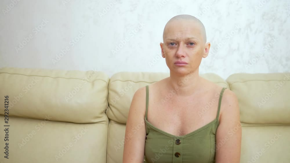 depression sad bald woman with cancer after chemotherapy. sitting on the couch crying. depression sad bald woman with cancer after chemotherapy. sitting on the couch crying.