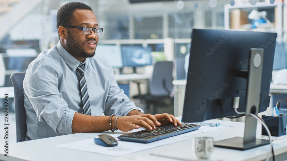 In the Industrial Engineering Facility: Portrait of the Smart and Handsome Male Engineer Working on Desktop Computer. In the Industrial Engineering Facility: Portrait of the Smart and Handsome Male Engineer Working on Desktop Computer.