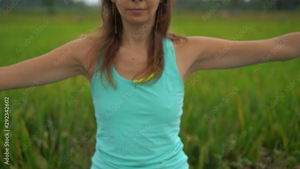 Slowmotion steadicam shot of a young woman doing meditation for Muladhara chakra in a Balinese way Slowmotion steadicam shot of a young woman doing meditation for Muladhara chakra in a Balinese way